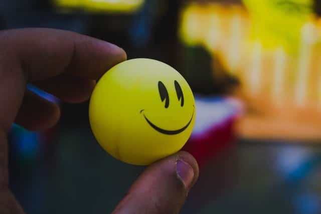 Gelber Tischtennisball mit einem Smiley