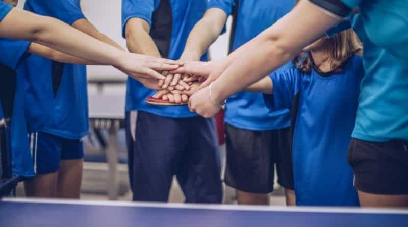 Viele Tischtennisspieler halten ihre Hände übereinander
