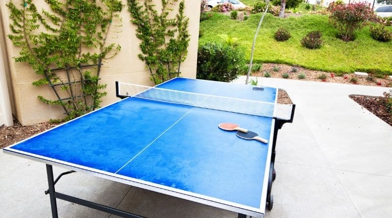 Blaue Tischtennisplatte steht auf einer Terrasse