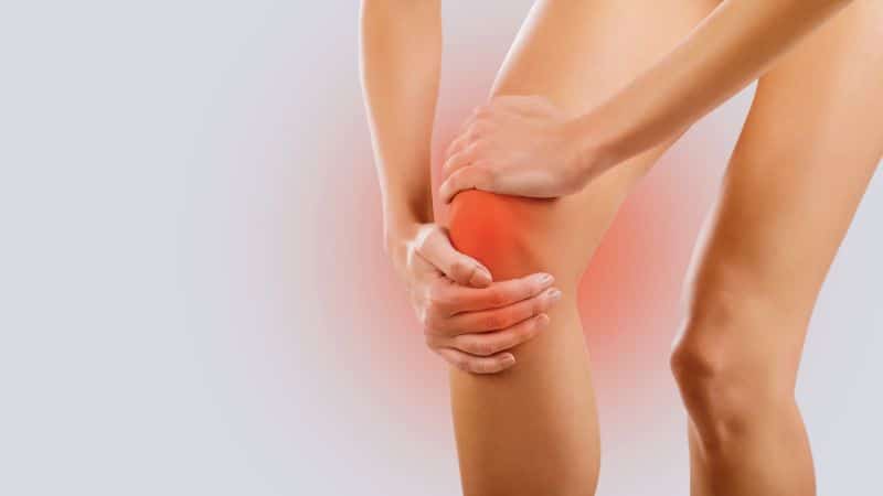 Grafik mit Frau, die Schmerzen im Knie hat